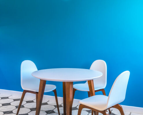 Vue du coin repas avec sa table ronde blanche et son piètement en noyer, par Elisabeth Hamard, architecte d'intérieur