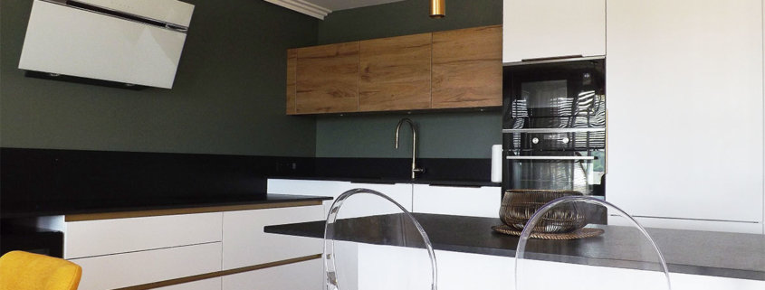 La cuisine dans des tons blancs et noirs réhaussé par le mur vert, par Elisabeth Hamard, architecte d'intérieur Toulon - Var