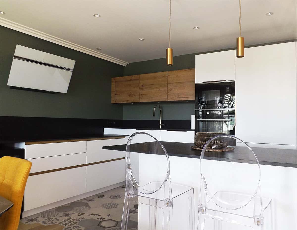 La cuisine avec son coin bar - La cuisine dans des tons blancs et noirs réhaussé par le mur vert, par Elisabeth Hamard, architecte d'intérieur Toulon - Var