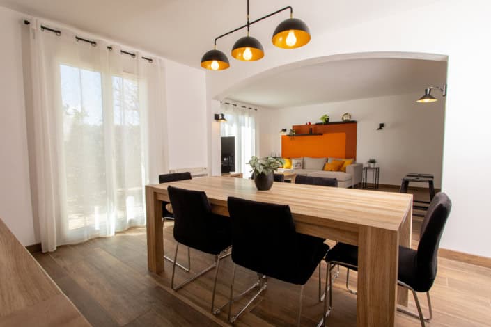 Vue du séjour avec la grande table à manger en chêne et le luminaire triple au look industriel, par Elisabeth Hamard, Architecte d'intérieur à Toulon • Var