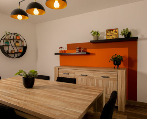 La salle à manger avec ses étagères murales et le décor peint dans des tons orangés, par Elisabeth Hamard, architecte d'intérieur- Toulon- Var