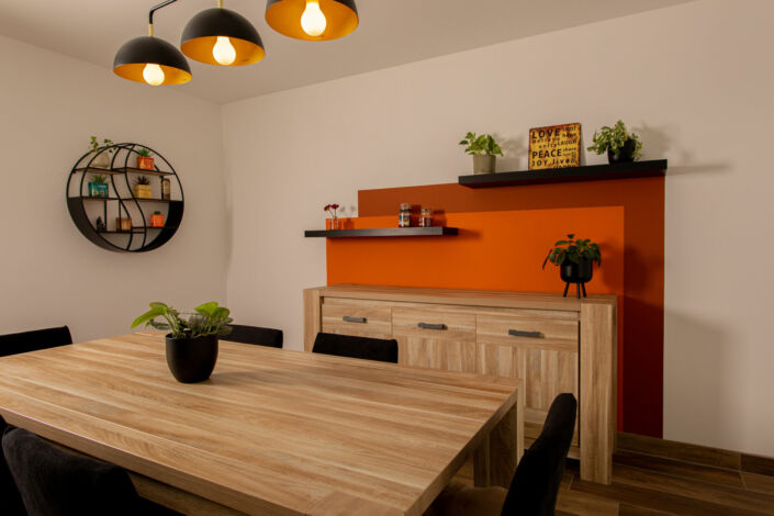 La salle à manger avec ses étagères murales et le décor peint dans des tons orangés, par Elisabeth Hamard, architecte d'intérieur- Toulon- Var